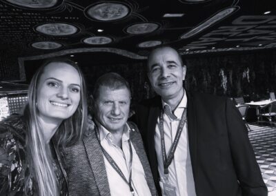 Deux hommes et une femme debout avec des tour de coups Expering se prennent en selfie dans un intérieur